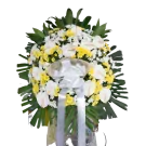 White and yellow flowers with green foliage in sympathy standing spray arrangement