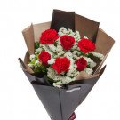 Red roses and white baby's breath flowers in kraft and dark paper wrapping bouquet