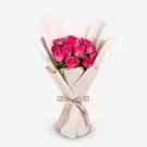 Vibrant pink roses elegantly wrapped in cream paper with pink ribbon bow
