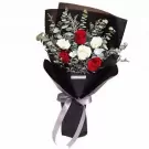 Elegant bouquet with red and white roses, green foliage, black wrapping and ribbon