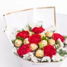 Red carnations with white chrysanthemums and gold chocolate candies in white wrapping