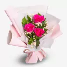 Pink roses bouquet with baby's breath and green leaves wrapped in light pink paper