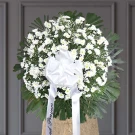 White daisies and roses with green foliage in sympathy standing spray arrangement
