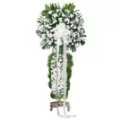 White floral standing spray with green foliage and white ribbon bow