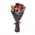 Red and white roses bouquet with burgundy ribbon bow and dark wrapper