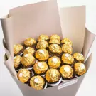 Bouquet of gold-wrapped chocolate bonbons arranged in cream wrapping paper