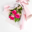 Elegant bouquet of three vibrant pink roses with white baby's breath and green foliage