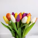 Colorful assorted tulips bouquet with orange, yellow, purple, and white stems in vase arrangement