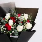 Red and white roses with greenery in black wrap bouquet arrangement