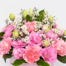 Pink peonies and roses with white daisies and green buds in lush arrangement