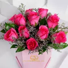 Miss Anne bouquet featuring twelve vibrant hot pink roses with green foliage in pink box