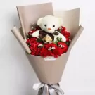 Teddy Love bouquet with white bear, red roses, and baby's breath in kraft paper wrapping