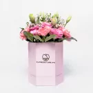 Pink carnations and white lisianthus in a pink hexagonal box with branding