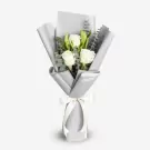 Elegant white roses bouquet with green foliage wrapped in gray and white paper