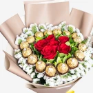 Luxurious bouquet with red roses, golden chocolates, and white baby's breath in beige wrapping