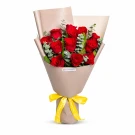 Red roses bouquet with eucalyptus greenery wrapped in beige paper with yellow ribbon