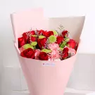 Red roses with pink carnations and yellow chrysanthemums in pink wrapped bouquet