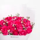 Vibrant pink roses with white baby's breath flowers arranged in elegant bouquet