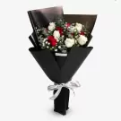 Elegant black-wrapped bouquet with red roses, white flowers, and green foliage with silver ribbon