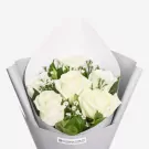 White roses with green foliage wrapped in gray paper bouquet arrangement
