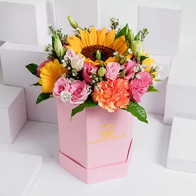 Colorful flower arrangement with yellow sunflowers, pink roses, and orange gerberas in pink box