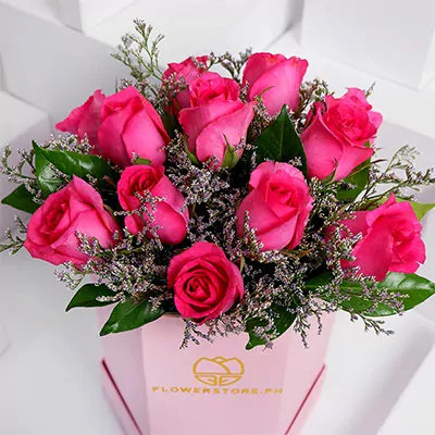 Miss Anne bouquet featuring twelve vibrant hot pink roses with green foliage in pink box