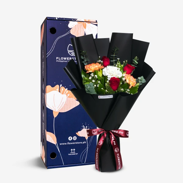 Black-wrapped bouquet with red roses, orange gerberas, and white flowers with burgundy ribbon