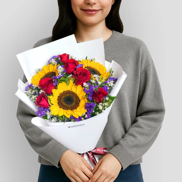 Vibrant bouquet with sunflowers, red roses, purple statice, and white baby's breath in white wrapping
