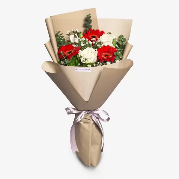 Elegant bouquet of red gerberas, white rose, and white baby's breath in kraft paper wrapper