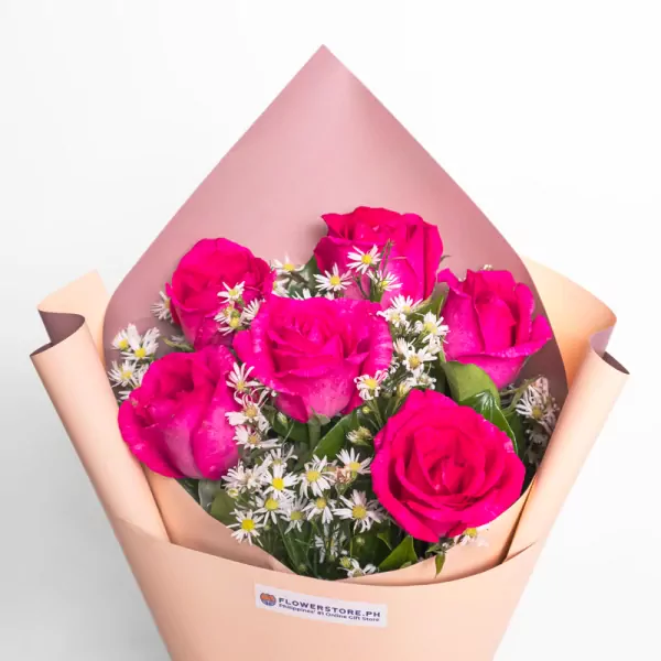 Vibrant magenta roses with white daisies in peach wrapping paper bouquet