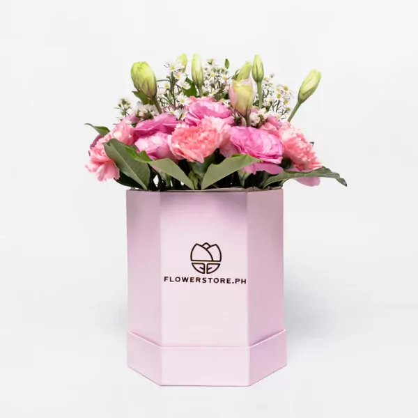 Pink carnations and white lisianthus in a pink hexagonal box with branding