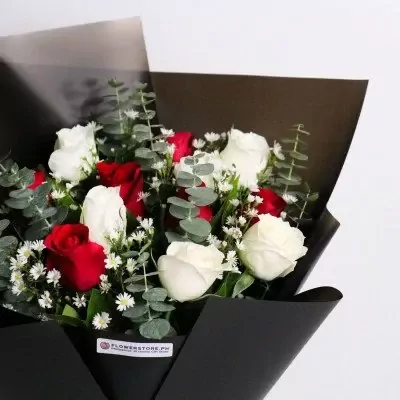 Red and white roses with greenery in black wrap bouquet arrangement
