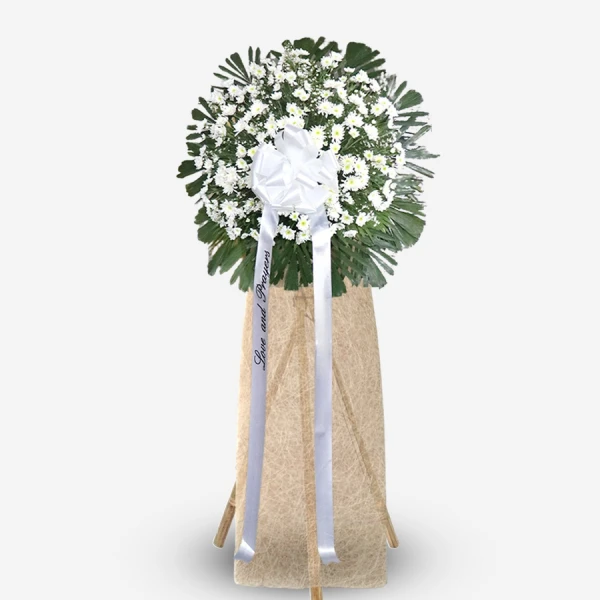 White roses and baby's breath with green foliage on beige standing easel