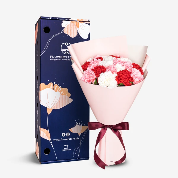 Pink and red carnation bouquet with white flowers wrapped in pink paper with burgundy ribbon