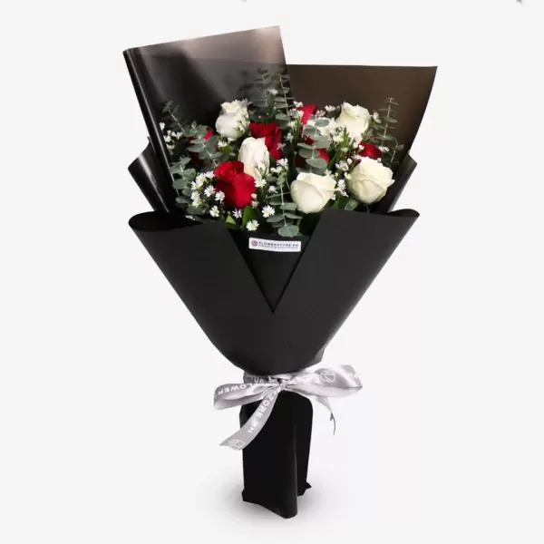Elegant black-wrapped bouquet with red roses, white flowers, and green foliage with silver ribbon