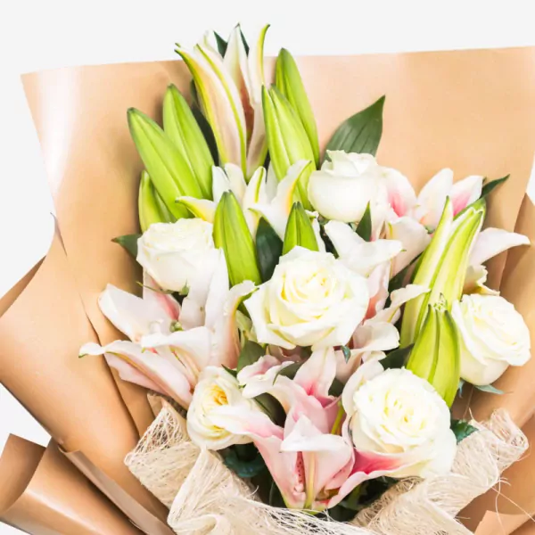 Elegant bouquet featuring white roses, pink cymbidium orchids, and green lily buds wrapped in kraft paper