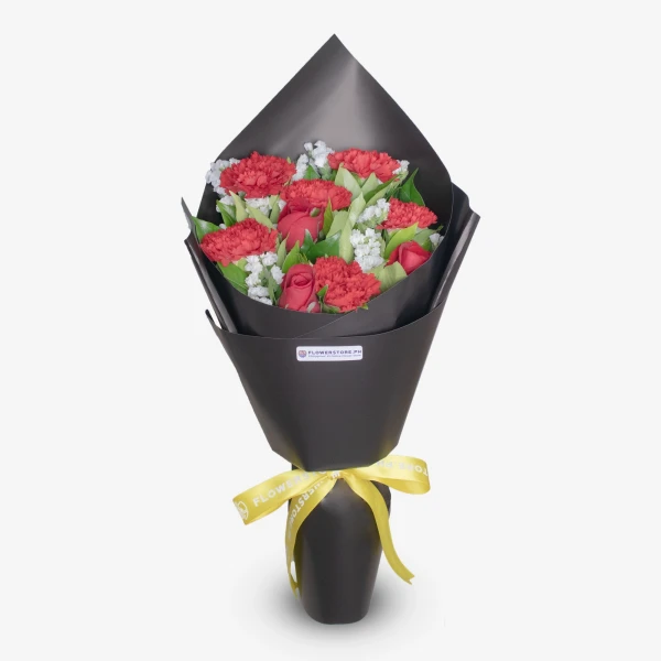Elegant bouquet of pink carnations, red roses, white filler flowers in black wrapper with gold ribbon