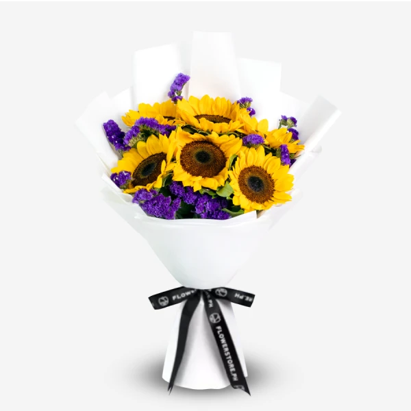 Sunflower bouquet with yellow blooms and purple statice wrapped in white paper with black ribbon