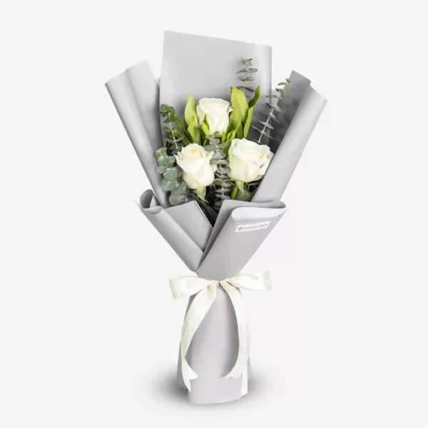 Elegant white roses bouquet with green foliage wrapped in gray and white paper