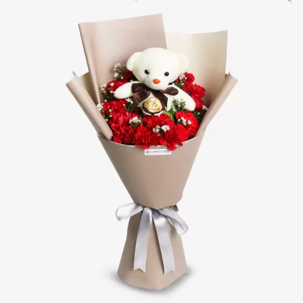 Red carnations with white teddy bear and chocolate, cream paper wrap bouquet