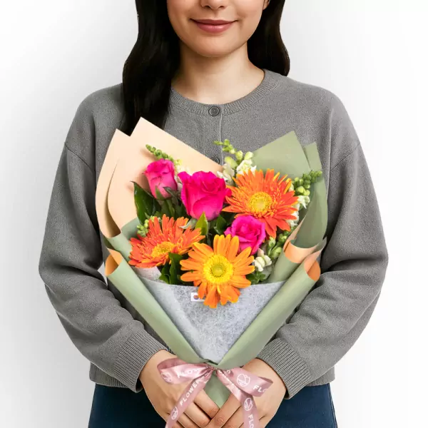 Vibrant bouquet with orange gerberas, pink roses, and white filler flowers in green wrap