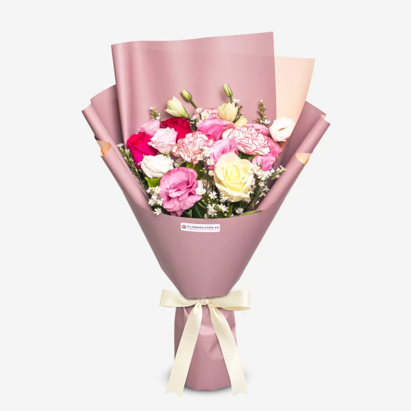 Vibrant mixed flower bouquet with pink, red, and yellow blooms wrapped in mauve paper