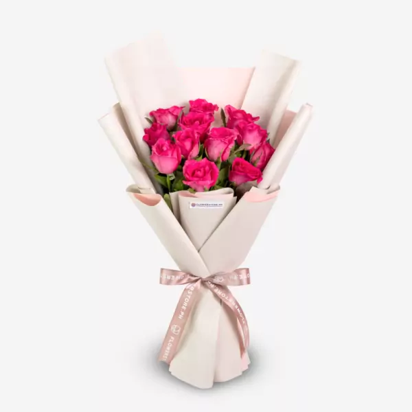 Vibrant pink roses elegantly wrapped in cream paper with pink ribbon bow
