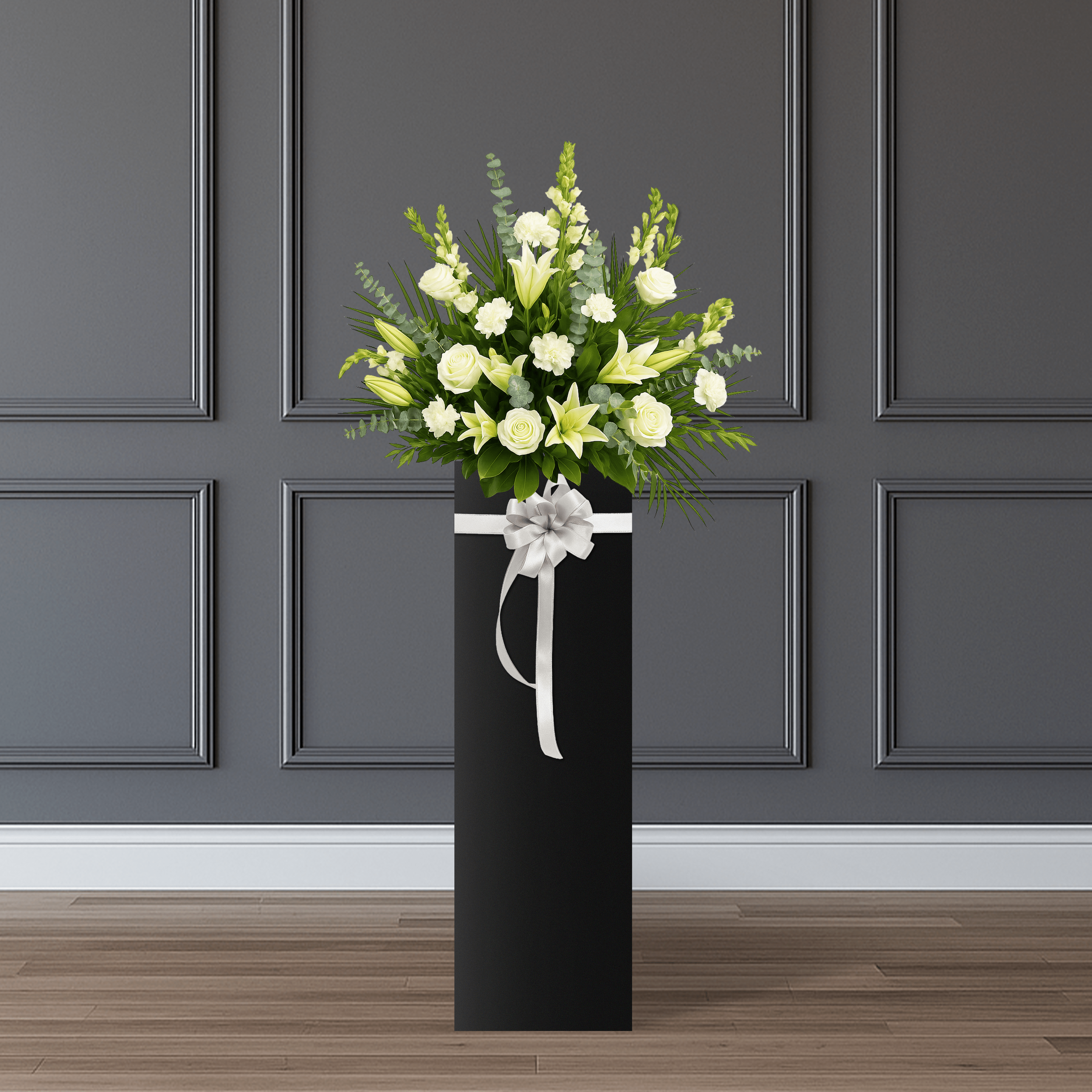 This arrangement consists of white lilies, white carnations, white roses, and white eustoma, accented with palm, eucalyptus, and rosal leaves.   