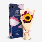 Sunflower bouquet with pink carnations and chrysanthemums, next to a dark blue gift box with floral design.