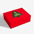 Red Christmas gift box with a green Christmas tree decoration that says "Have a Merry Christmas."