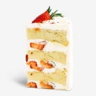 Slice of strawberry cake with cream and a strawberry and rosemary garnish.