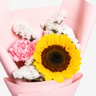 Sunflower and pink carnations in a pink bouquet wrapper.