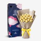 Ferrero Rocher chocolate bouquet in gold wrappers, with brown paper and a yellow ribbon, next to a blue gift box.