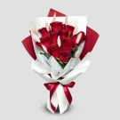 Bouquet of glittered red roses and bunny tails, wrapped in white and red paper with a red ribbon.
